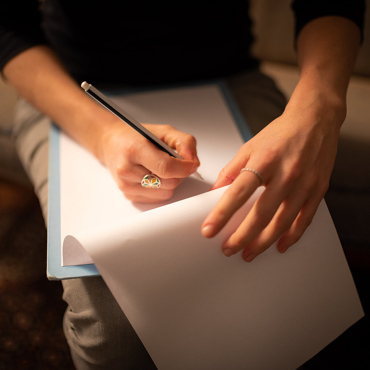 Nora Sevbihiv Sinemillioglu writes on a clipboard